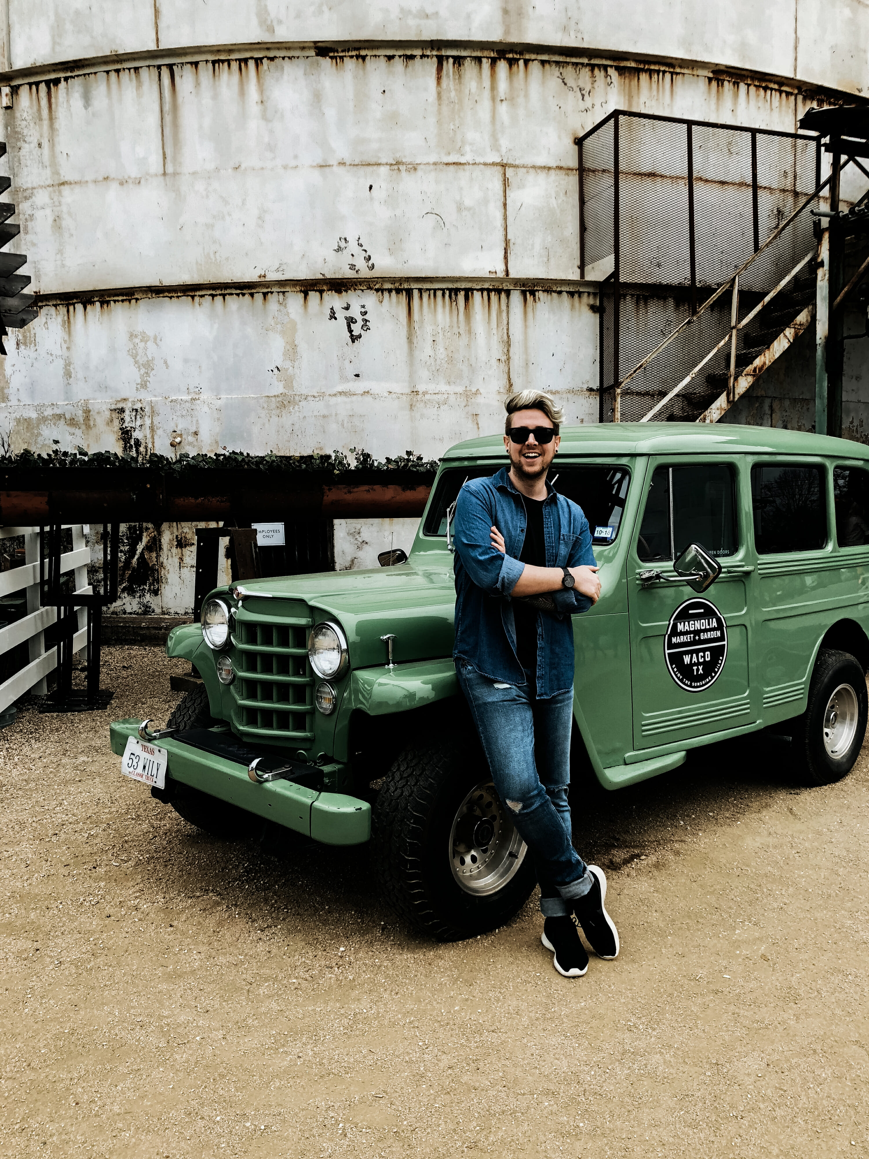 blonde man in front of green truck