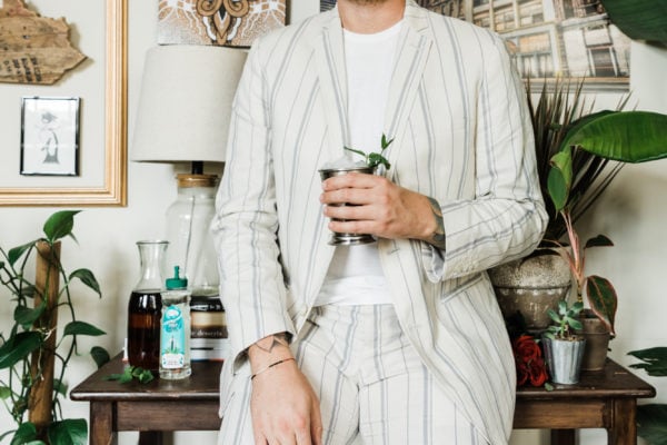man in white suit with mint julep