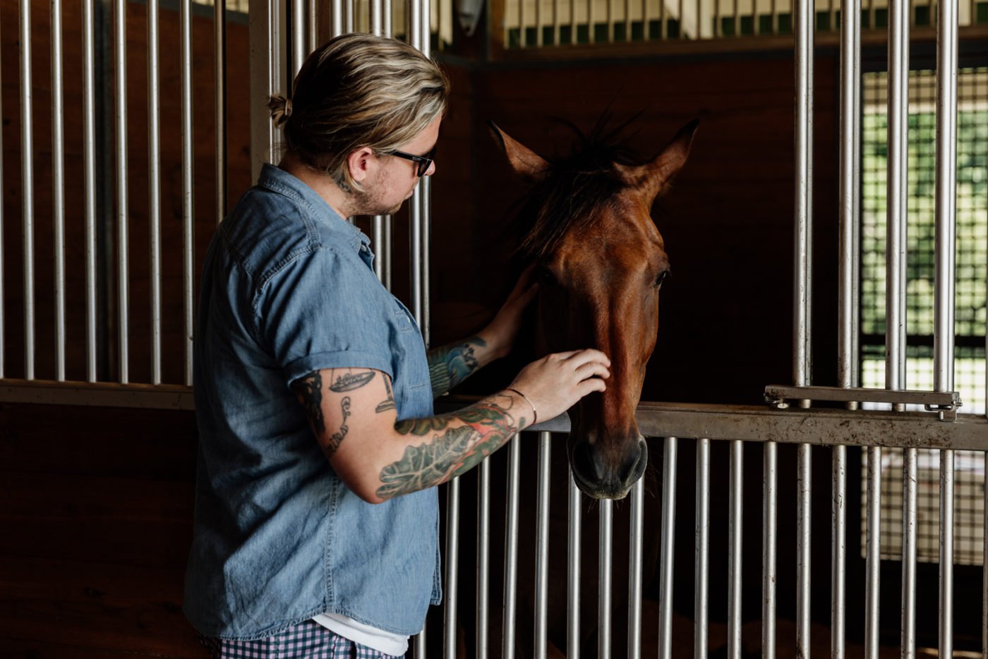 man petting horse